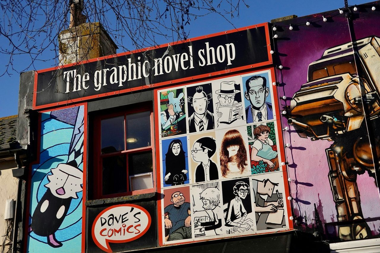 Cómics. Foto: <a href="https://unsplash.com/@nythfran?utm_source=Hoy%20Apps&utm_medium=referral" target="_blank" rel="noopener">Trevor John Williams</a> (<a href="https://unsplash.com/photos/graphic-novel-shop-storefront-with-mural-gj-IkQ5-uUY?utm_source=Hoy%20Apps&utm_medium=referral" target="_blank" rel="noopener">Unsplash</a>)